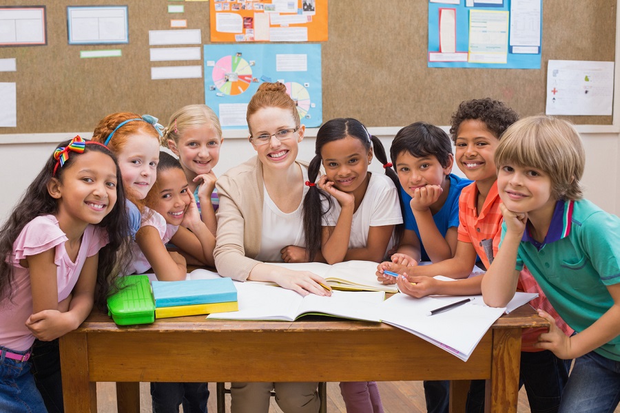 teacher and pupils working at desk together